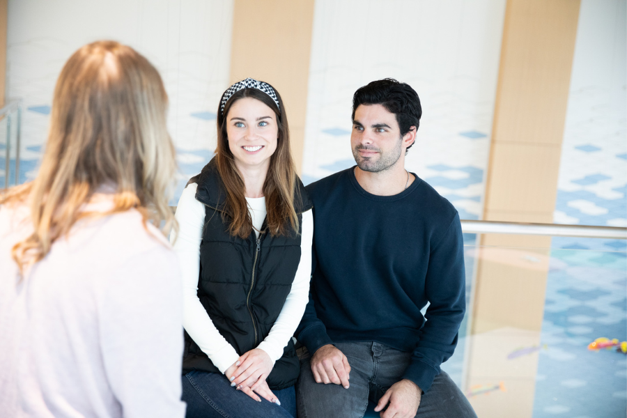 women's provider talking to young couple