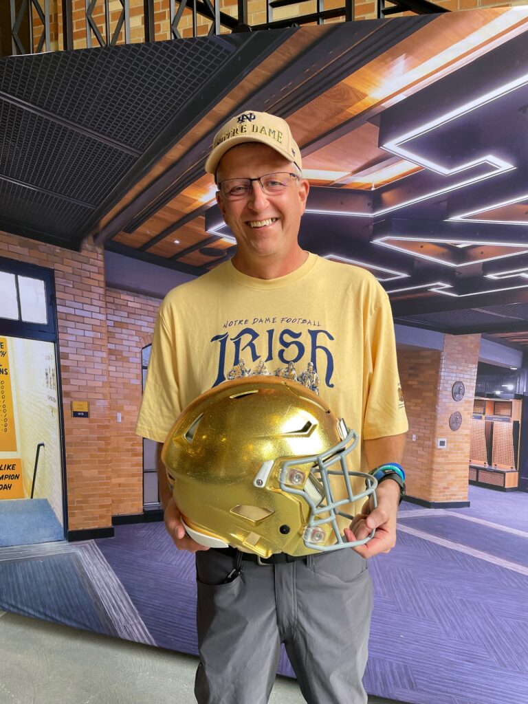 Greg Berger smiles with his helmet